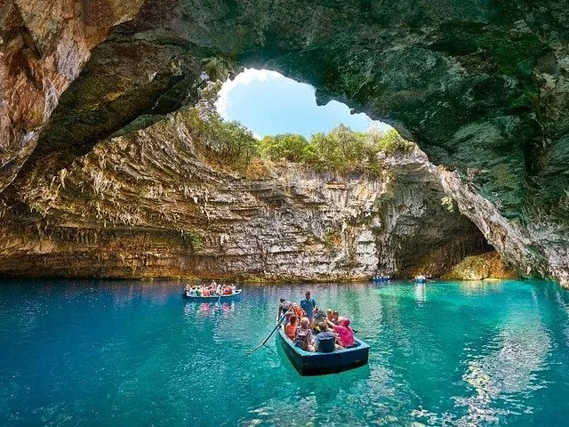 Une autre vue d'un bateau touristique explorant la grotte de Melissani aux eaux éclatantes.
