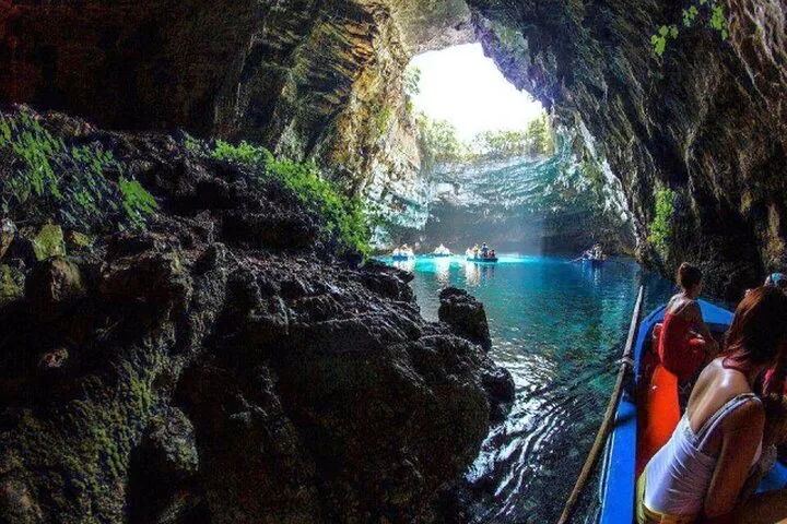 View from a boat entering the sunlit chamber of Melissani Cave.